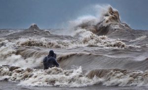 Photographer, Dave Sandford stands in the water to capture waves on Lake Erie. CREDIT DAVID HINTON