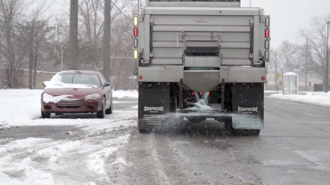 A truck spreading salt during a snow fall