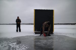 Ice fisherman preparing to fish for lake sturgeon on Black Lake in Michigan. Photo courtesy of Great Lakes Today