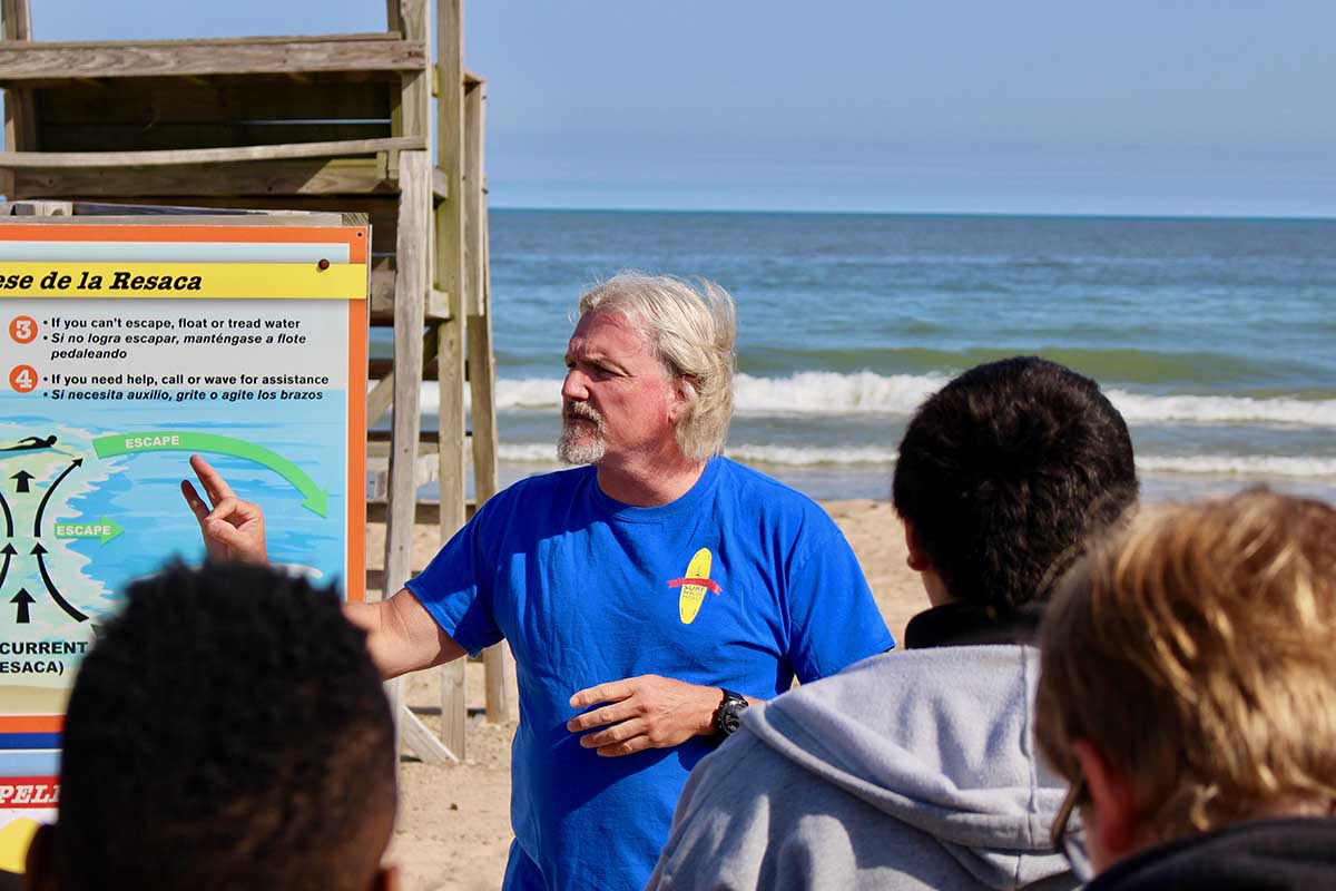 On the shores of Lake Michigan, Bob Pratt, founder of the nonprofit Great Lakes Surf Rescue Project, teaches Michigan City middle schoolers how to stay safe in the Great Lakes and other waters. (Bridge photo by Jim Malewitz)