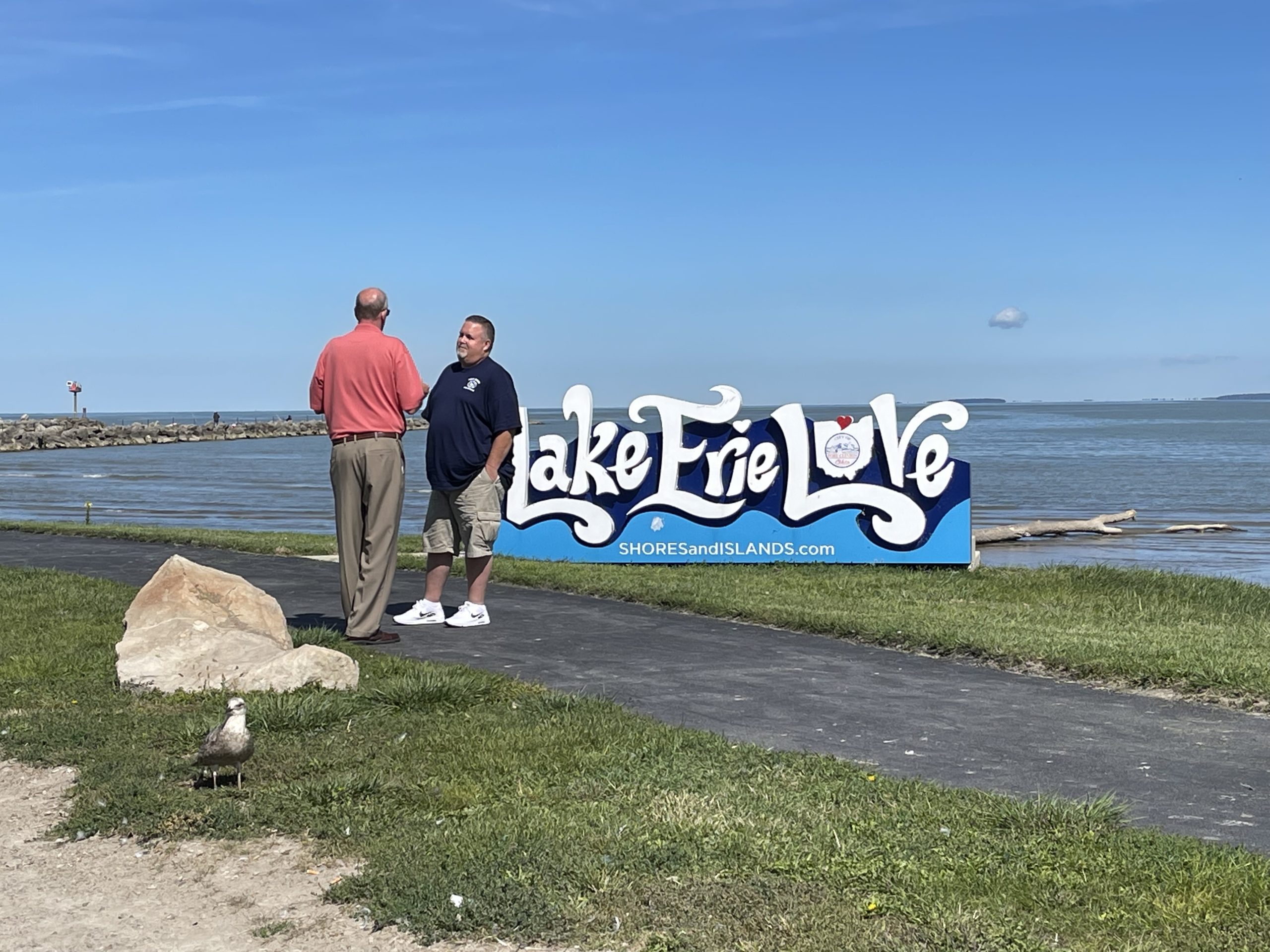 Port Clinton Mayor Mike Snider chats with a resident in front of a "Lake Erie Love" sign
